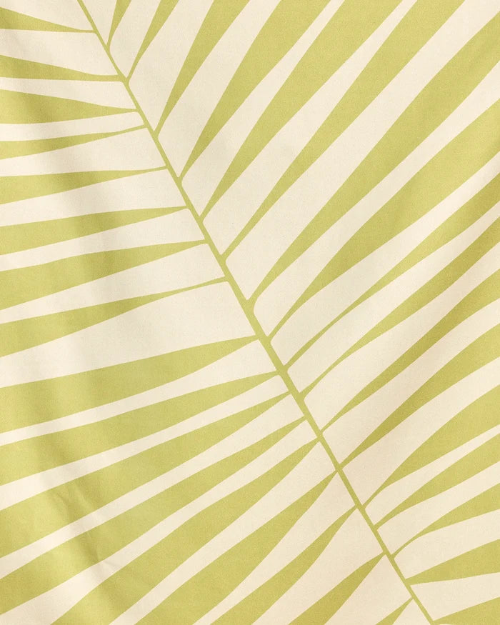 Cabana Club by Geometry features a pale yellow and cream abstract leaf pattern with diagonal lines radiating from a central vein—resembling a palm frond. Its simple, geometric design is perfect for their quick-drying beach blanket made from recycled materials.