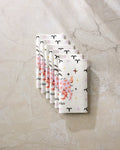Six folded "Daring Aries" cloth napkins by Heather Zhou, featuring ram horns, stars, and "Aries," are arranged diagonally on marble—a stylish, eco-friendly alternative to paper towels for your home.