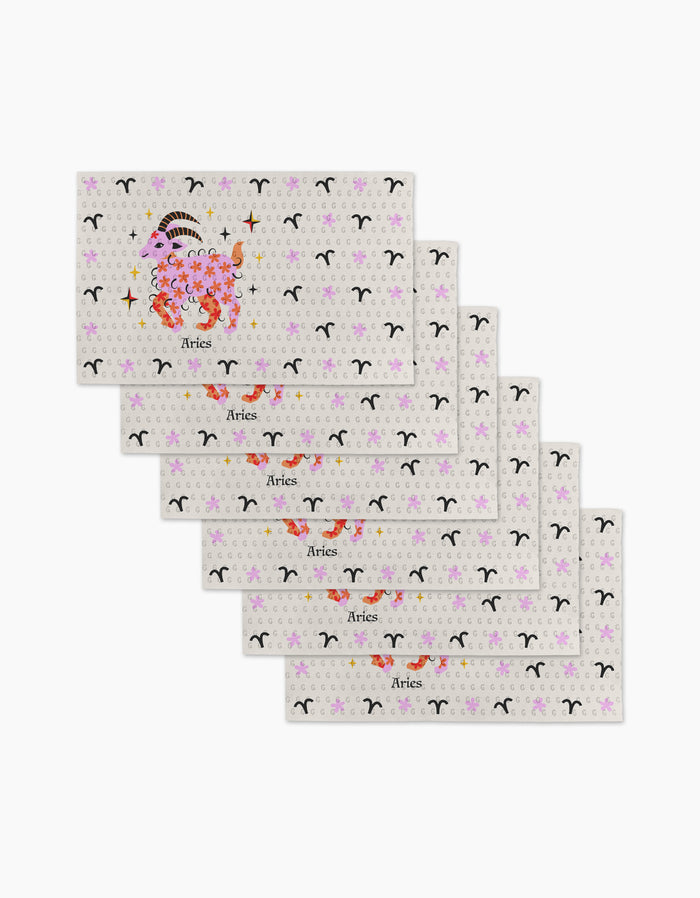 Six "Daring Aries" cards by Heather Zhou are fanned out, each showing a floral ram illustration, the word Aries, and a repeating Aries zodiac symbol—evoking the charm of eco-friendly kitchen towels.