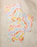 The Geometry Fish Flip set features three super-absorbent square dishcloths in pastel fish patterns, made from recycled materials and shown on a light marble surface.