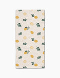 The Freshly Picked Bar Towel by Sara Mari is a rectangular beige towel with yellow lemons, lemon slices, green leaves, and dots. Made from Geoweave fabric for superior absorbency and durability.