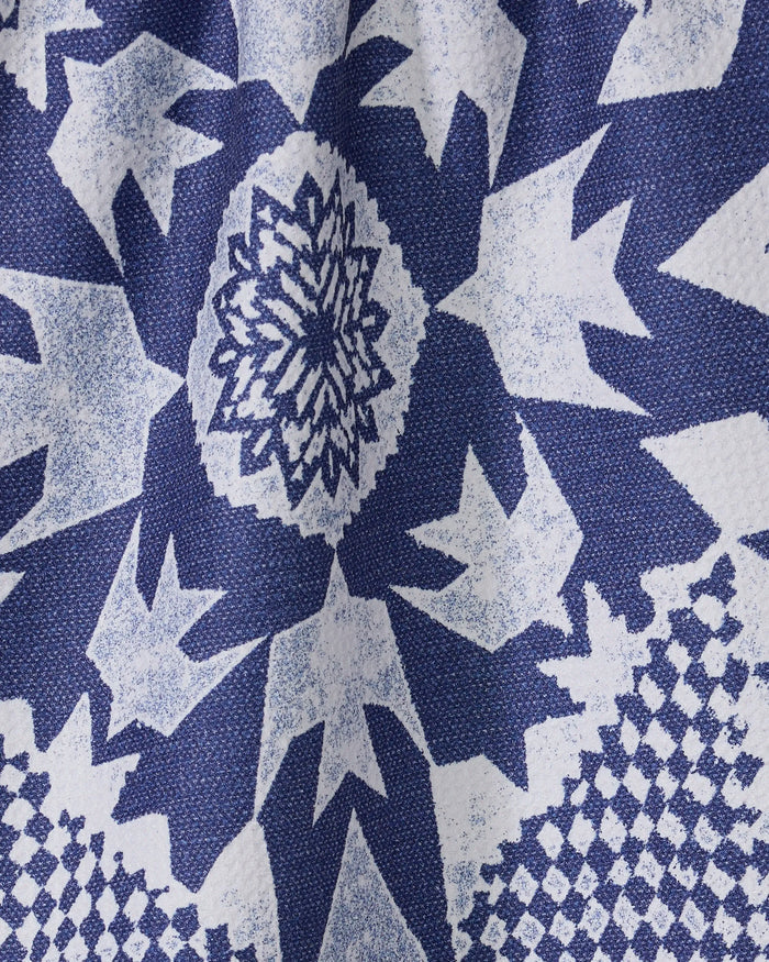Close-up of Geometry’s Froststar kitchen towel featuring a blue and white geometric star pattern with jagged edges and a central floral motif, made from textured recycled materials.