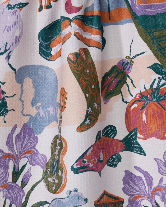 The Geometry "Greetings From Tennessee" tea towel features a colorful illustration of cowboy boots, a guitar, sushi, and more on a textured white surface. Made from recycled materials, it dries quickly.