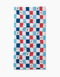 The Lightening Bolt Chess Bar Towel by Hufton Studio features a blue, red, and white checkered design with lightning bolts on Geoweave fabric, shown against a white background.