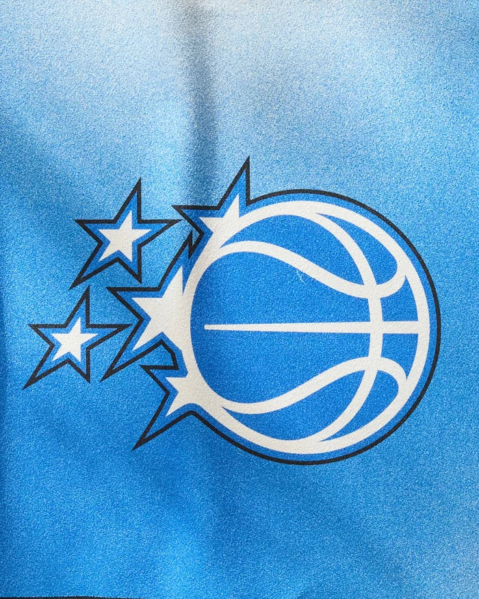 A stylized white basketball with blue lines and three stars on a blue gradient background captures the dynamic spirit of Magic Fade, the quick-drying workout towel by NBALAB x Geometry.