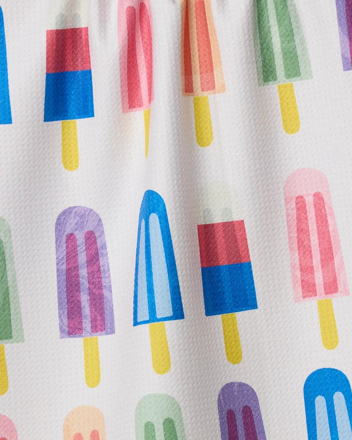The Geometry Poppy Popsicles tea towel features a delightful repeating pattern of playful pink, blue, green, purple, and red popsicles with yellow sticks on white textured fabric made from recycled materials.