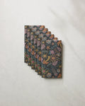 Six Sol Mar Black notebooks by Geometry, featuring vibrant marine-themed patterns, are arranged fan-style on a marble surface—an inspiring look for eco-friendly kitchen towels.