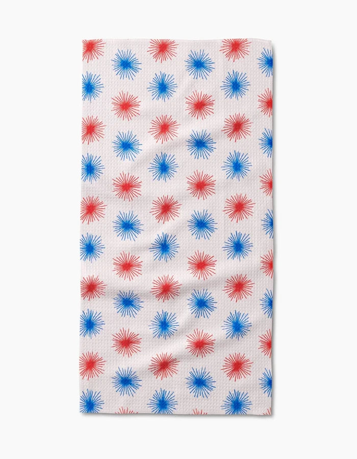 The Kayla Ann Sparkler Splash Bar Towel features a rectangular white Geoweave fabric with rows of evenly spaced red and blue starbursts for stylish, durable flair.
