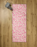 The Geometry Yoga Sheep mat features playful sheep poses on pink, resting on wood with a gray yoga block and recycled towel for extra comfort and eco-friendly support.